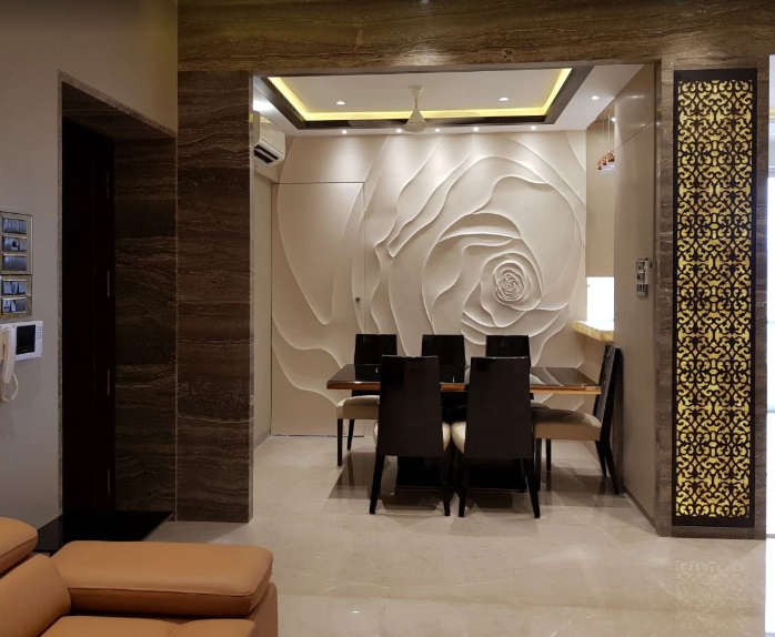 Hand-sculpted rose relief feature wall behind a dining setting, by Bhumi Decor